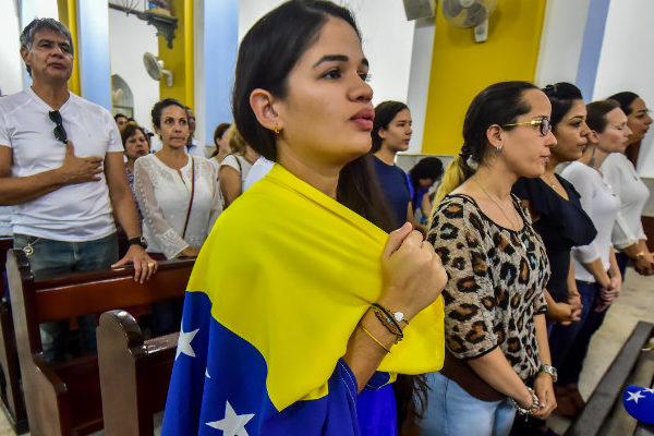 Venezolanos presionan por ayuda con rezos y agua bendita en Curazao