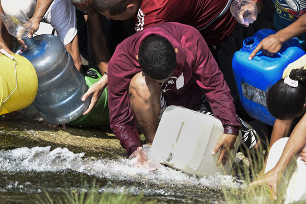 Venezolanos batallan por agua y comida ante lenta recuperación por apagón