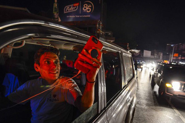 Familias enteras salen a buscar señal para sus celulares ante apagón en Venezuela