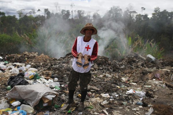 Venezolanos disputan restos de comida con buitres en un basurero en Brasil