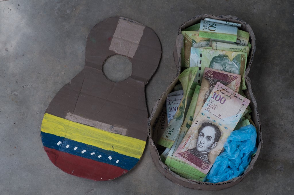 Billetes en desuso son el juguete de los niños en un pueblo de Venezuela