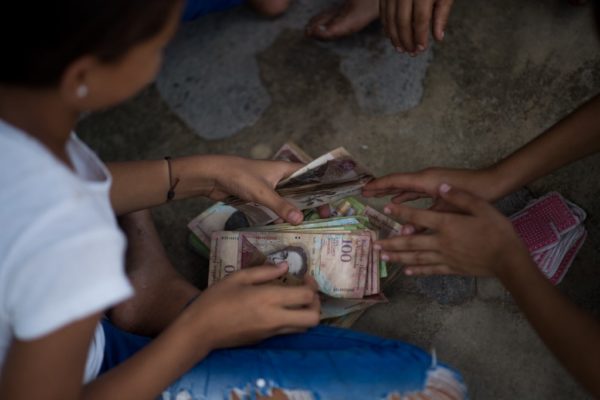 Billetes en desuso son el juguete de los niños en un pueblo de Venezuela